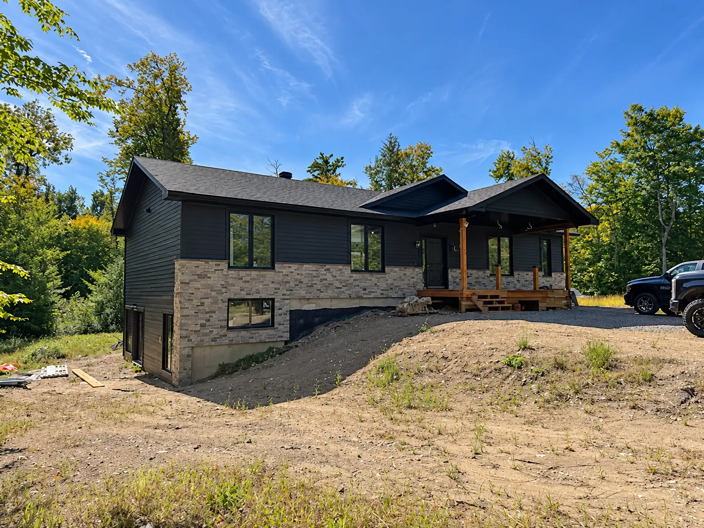 Maison avec revêtement extérieur en clin noir et pierre